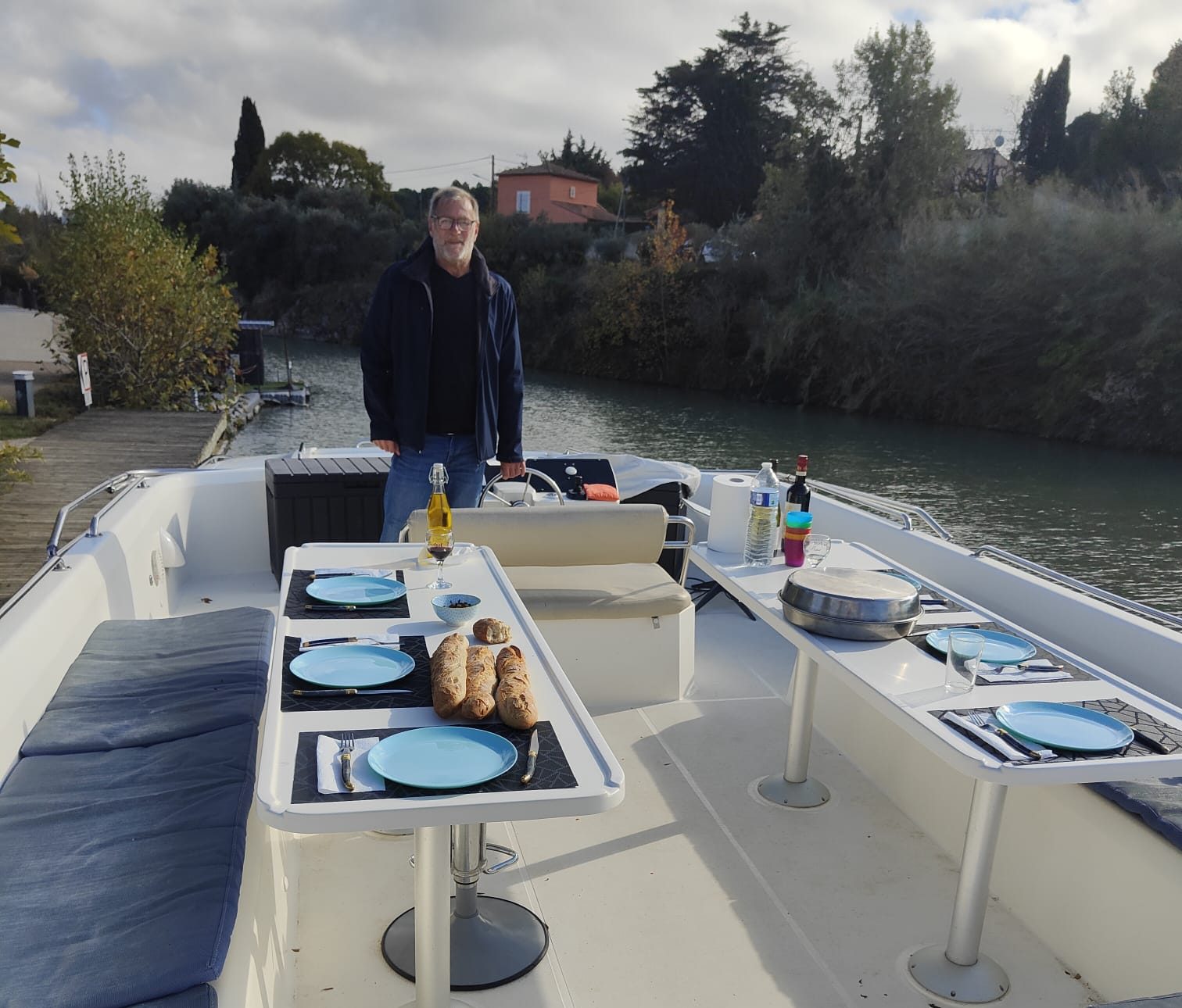 Skipper devant terrasse bateau Navylis table mise formule bateau d'hote